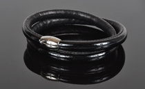 Armbånd i sort lak læder og sort kalveskind. 2 omgange med magnetlås i stål. Tykkelse 7,5 mm.